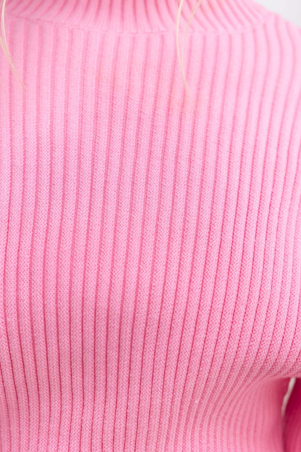 Close-up of Sola Jumper in vibrant pink with a ribbed texture and mock neckline.