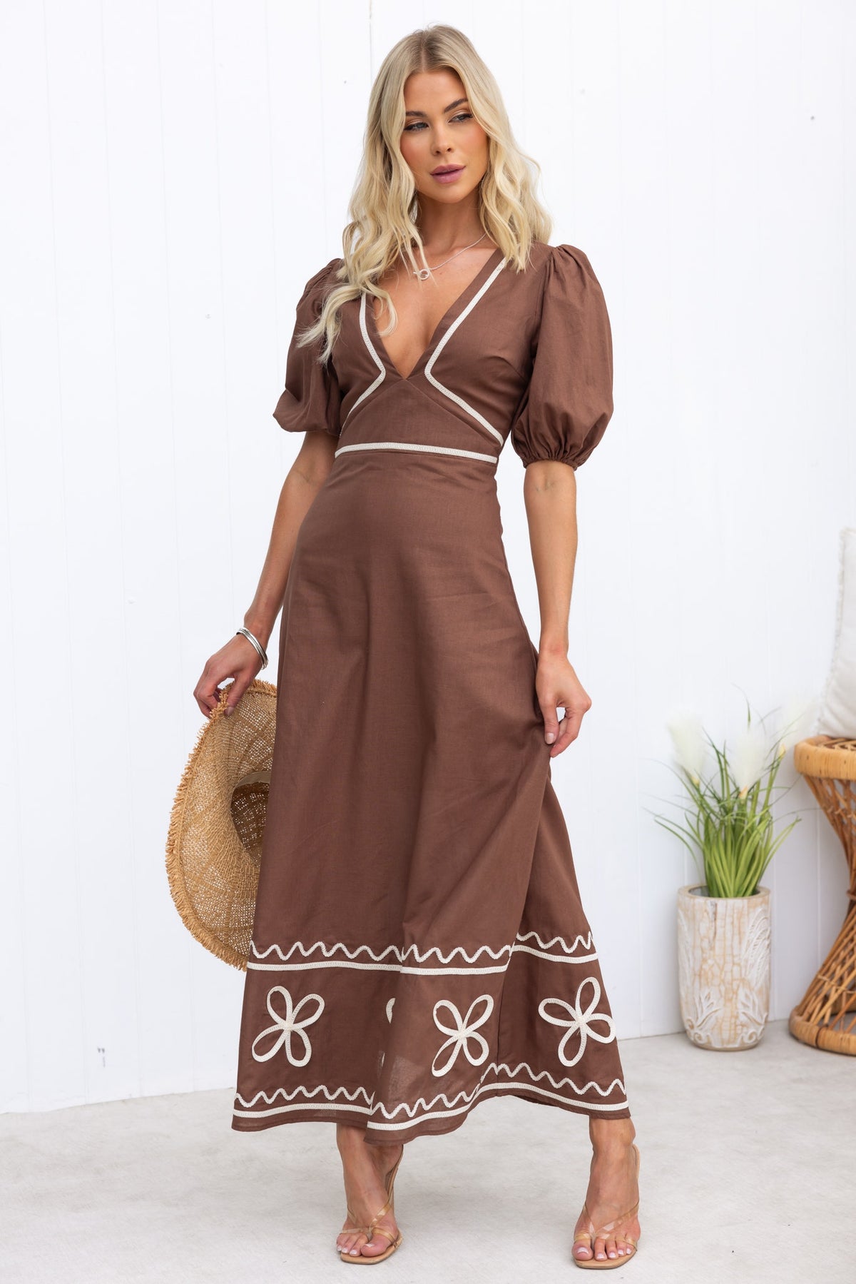 Elegant Azurra Maxi Dress in brown with V-neckline and puff sleeves, featuring floral embroidery and a flowing skirt.