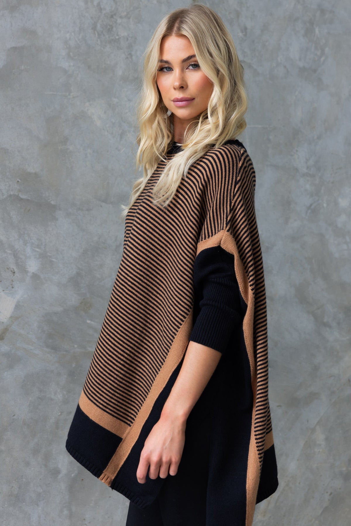 Woman modeling the Journey Jumper, featuring a round neckline, batwing sleeves, and stylish striped design.
