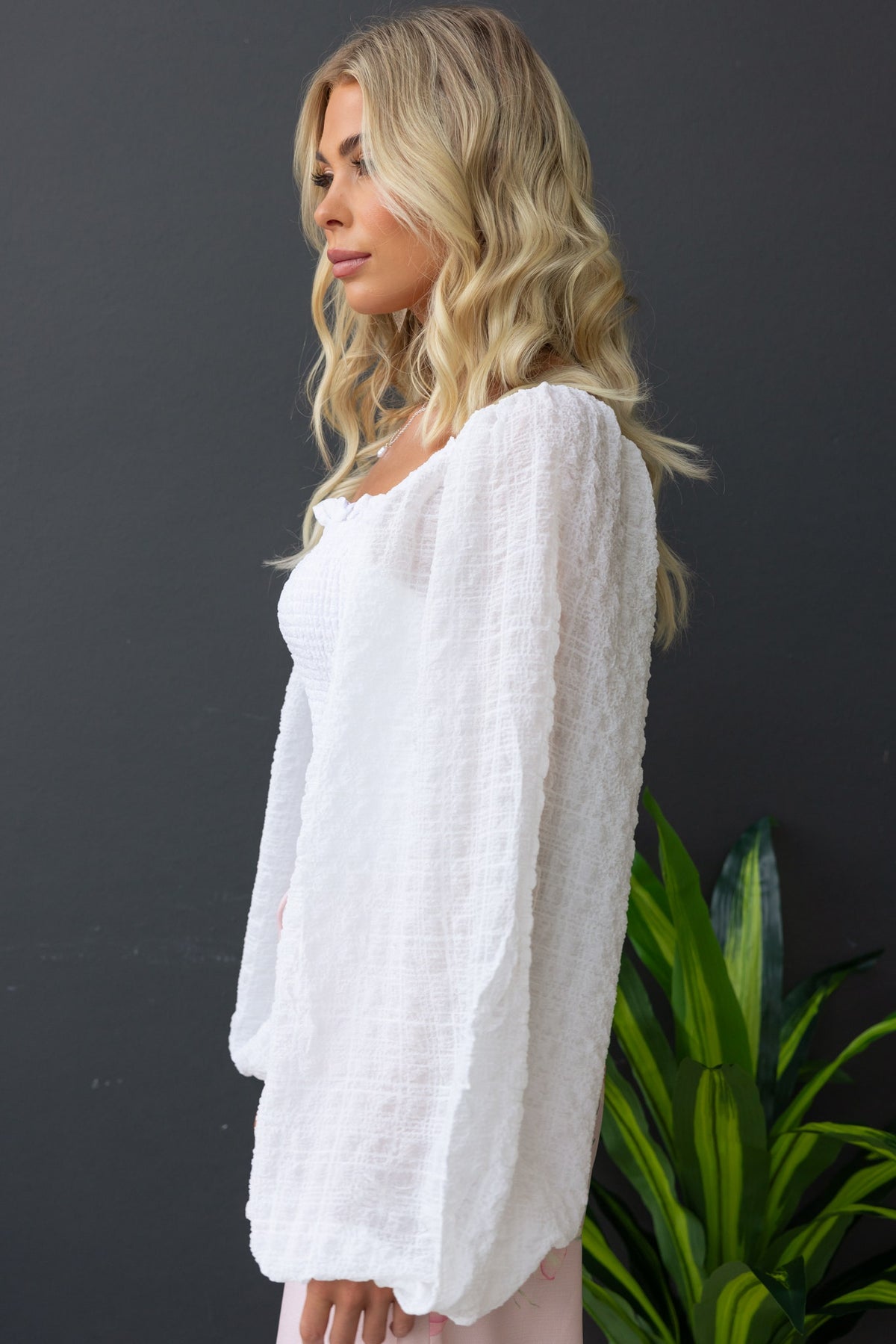 Joey Top featuring square neckline, elastic bodice, and textured white material, styled with long sleeves.