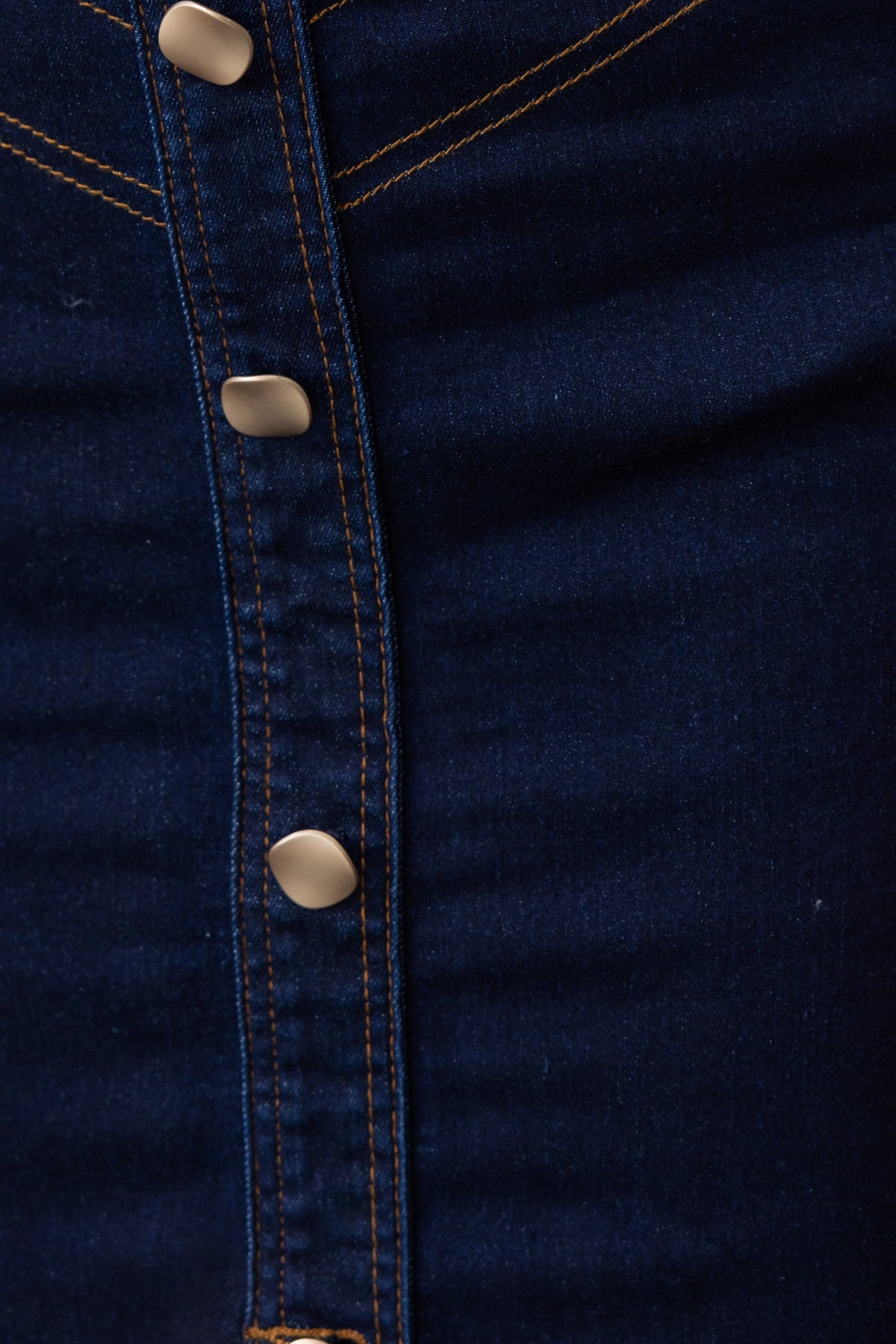 Close-up of Ovida Denim Skirt showcasing dark denim fabric and functional buttons down the front.