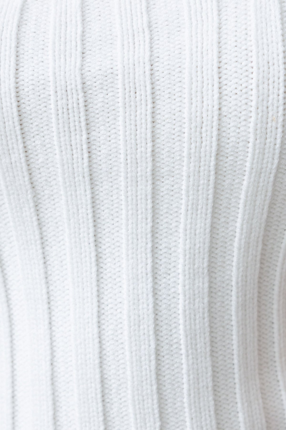 Close-up of white ribbed knit fabric, showcasing texture and stretch for a stylish top.