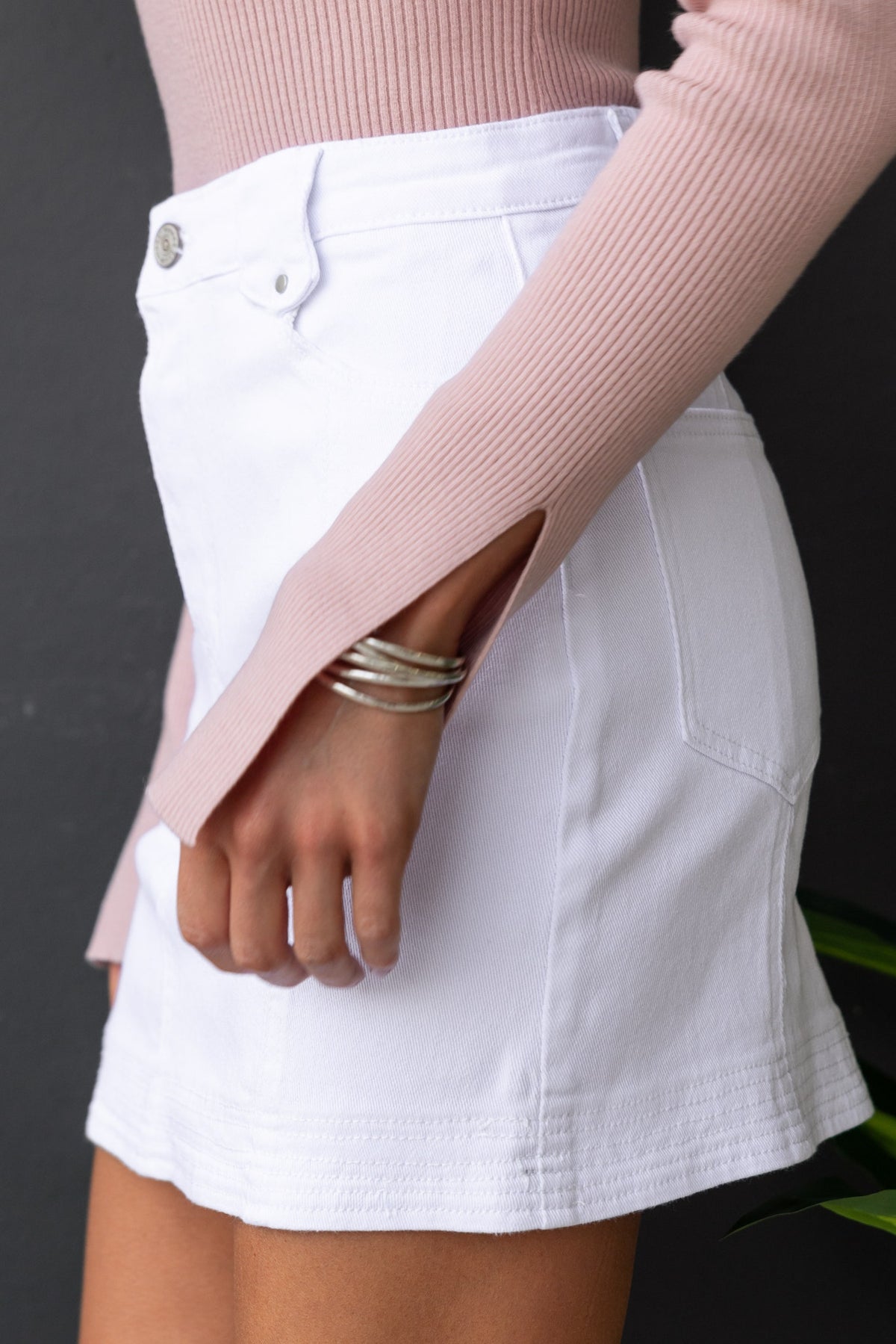 Model showcasing Hart Denim Skirt with mid-high waist, front and back pockets, styled with a ribbed pink top.