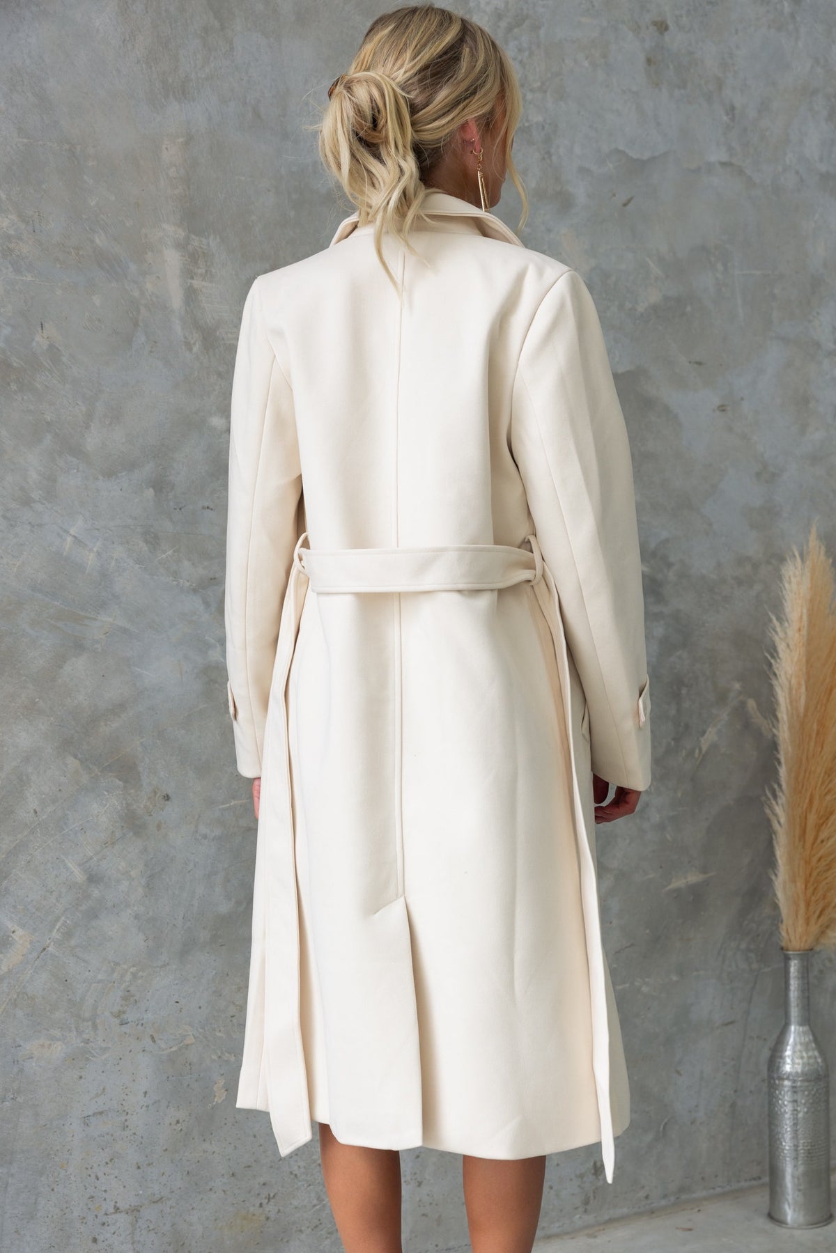 Back view of the Lansen Coat featuring a longline fit, removable tie, and split back design.