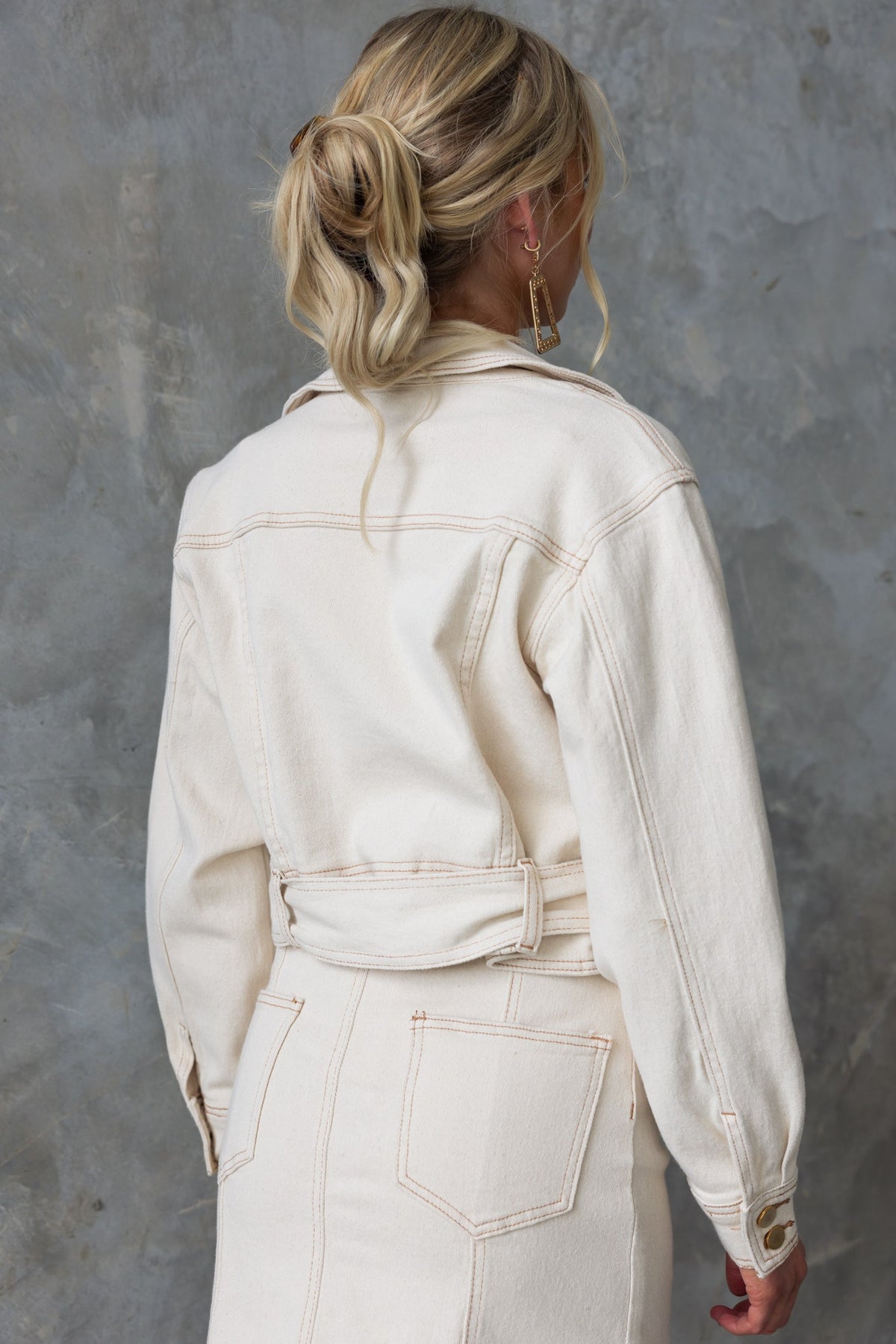 Back view of a stylish Kaylen Denim Jacket featuring a removable belt and slightly cropped fit.