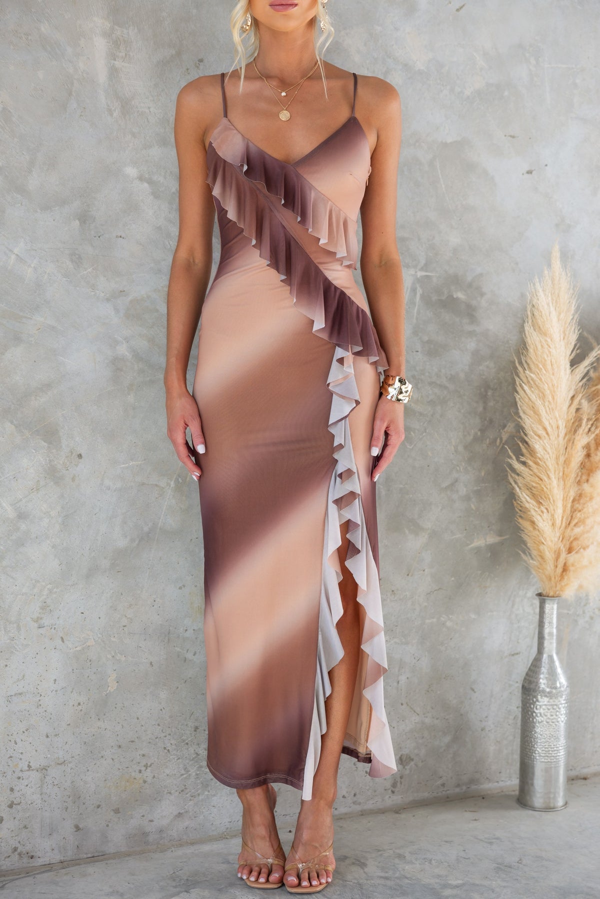 Model wearing Jillian Maxi Dress with ruffle detailing and adjustable straps, showcasing a chic look against a neutral background.