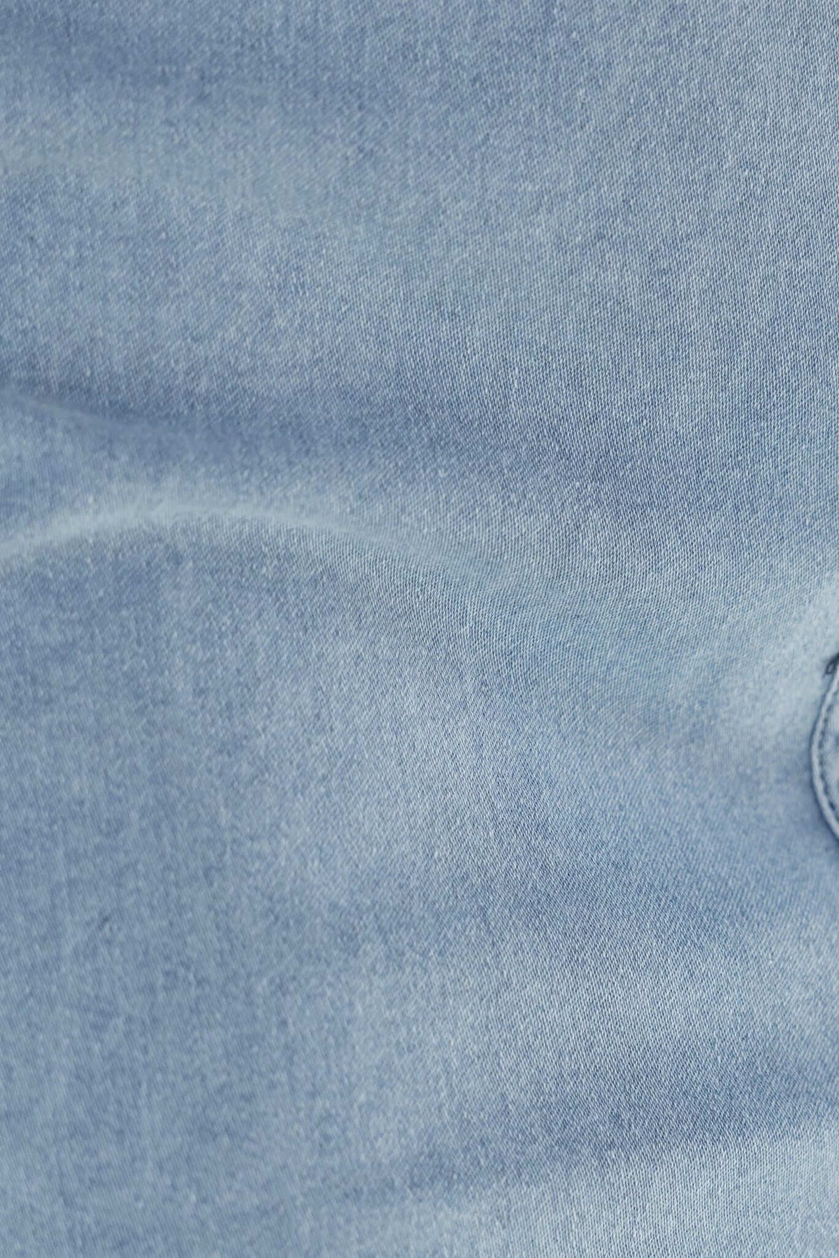 Close-up of light blue denim fabric, showcasing its soft texture and stretch quality, ideal for stylish denim dresses.