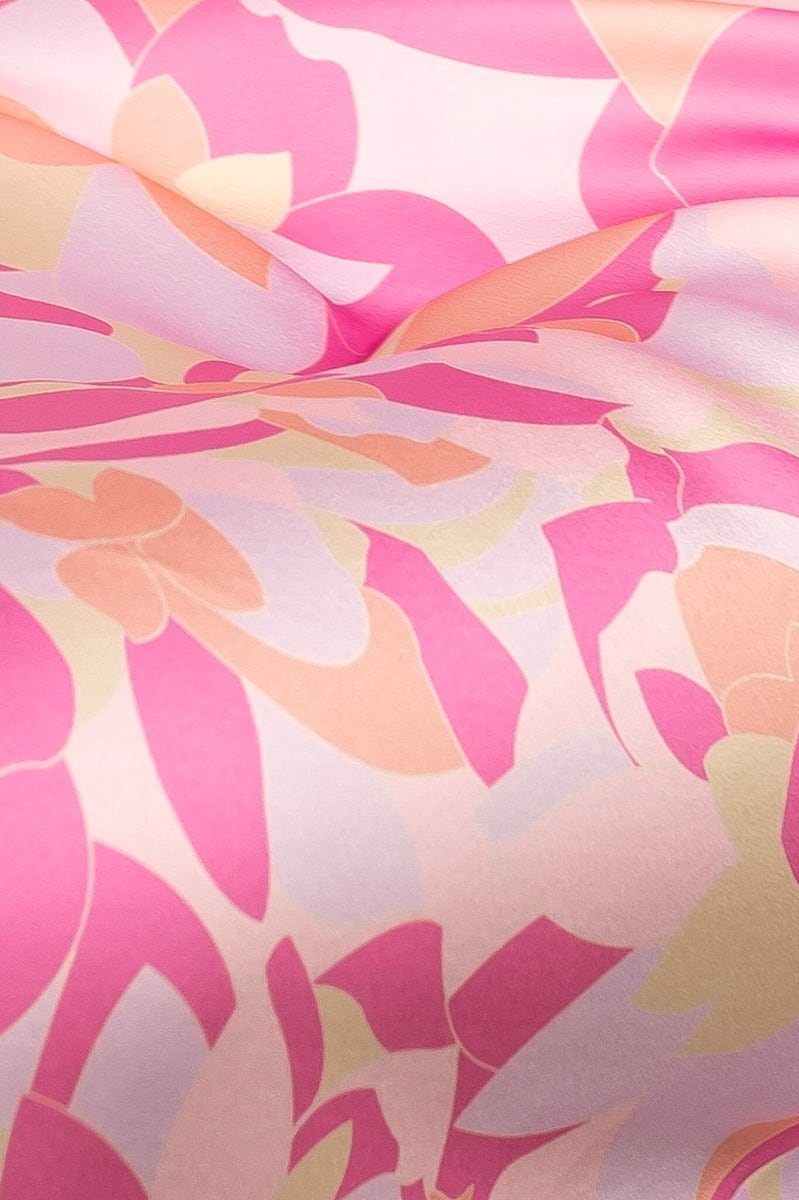 Close-up of the Gorgeous Day Midi Dress fabric featuring soft pink and peach floral patterns on satin material.