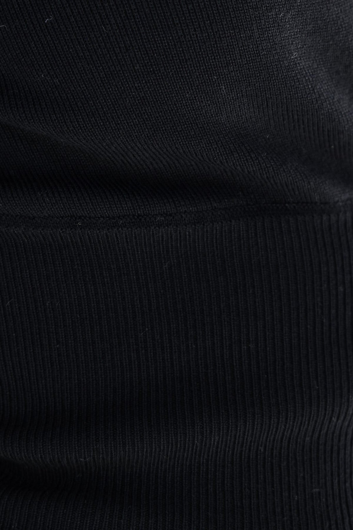 Close-up of the textured knit fabric of the Sania Top in black, showcasing its stretch and quality.