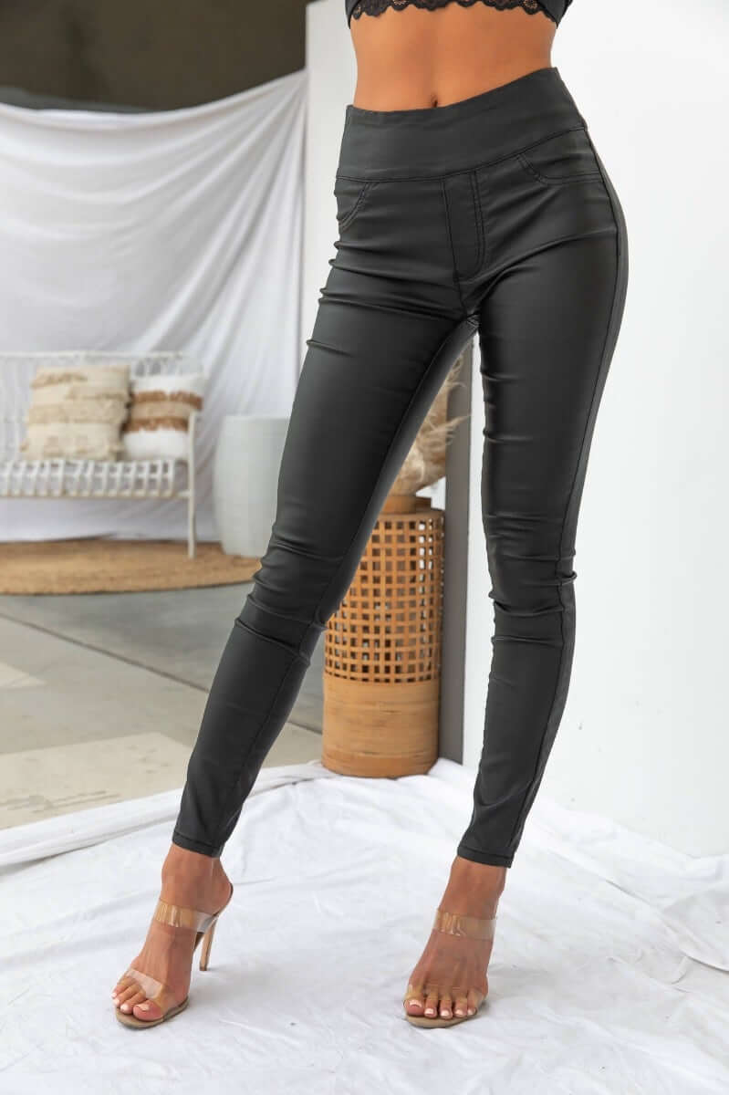 Damar Pants: Stylish wet look black pants with faux pockets, stretchy cotton blend, perfect for a chic outfit.