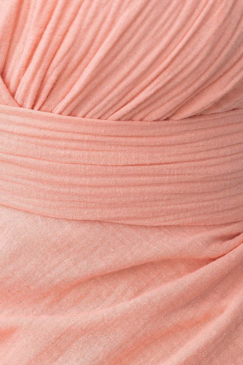 Close-up of the textured fabric and tie detail of the Gia Maxi Dress in soft pink, featuring an adjustable waist tie.