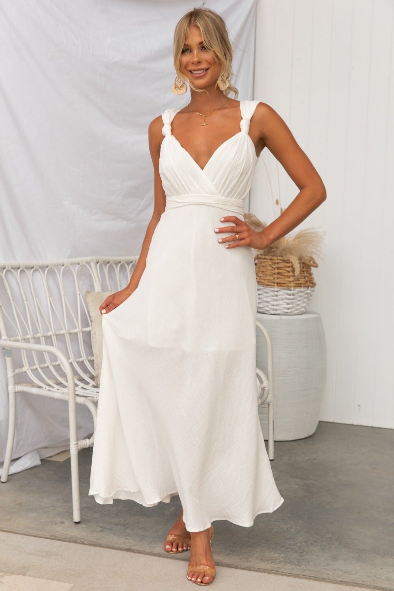 Model wearing the Gia Maxi Dress in white, showcasing textured material and elegant tie detail at the back.
