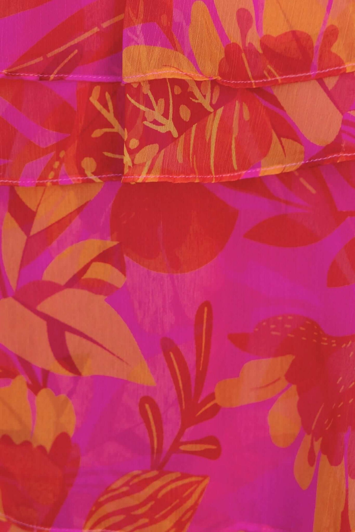 Vibrant floral pattern in shades of pink, orange, and red on a chiffon maxi dress fabric.