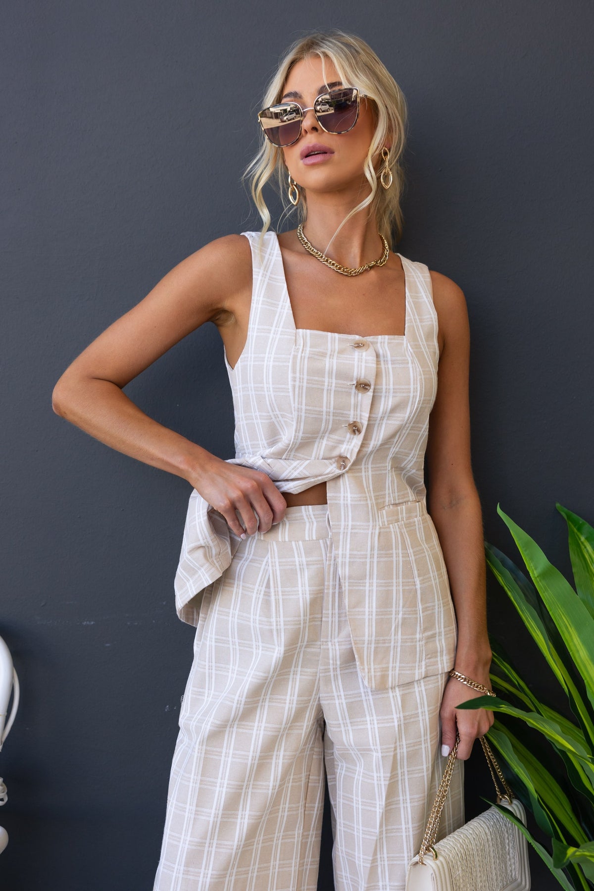 Bexley Top in plaid with button-up front, paired with high-waisted trousers, styled with sunglasses and accessories.