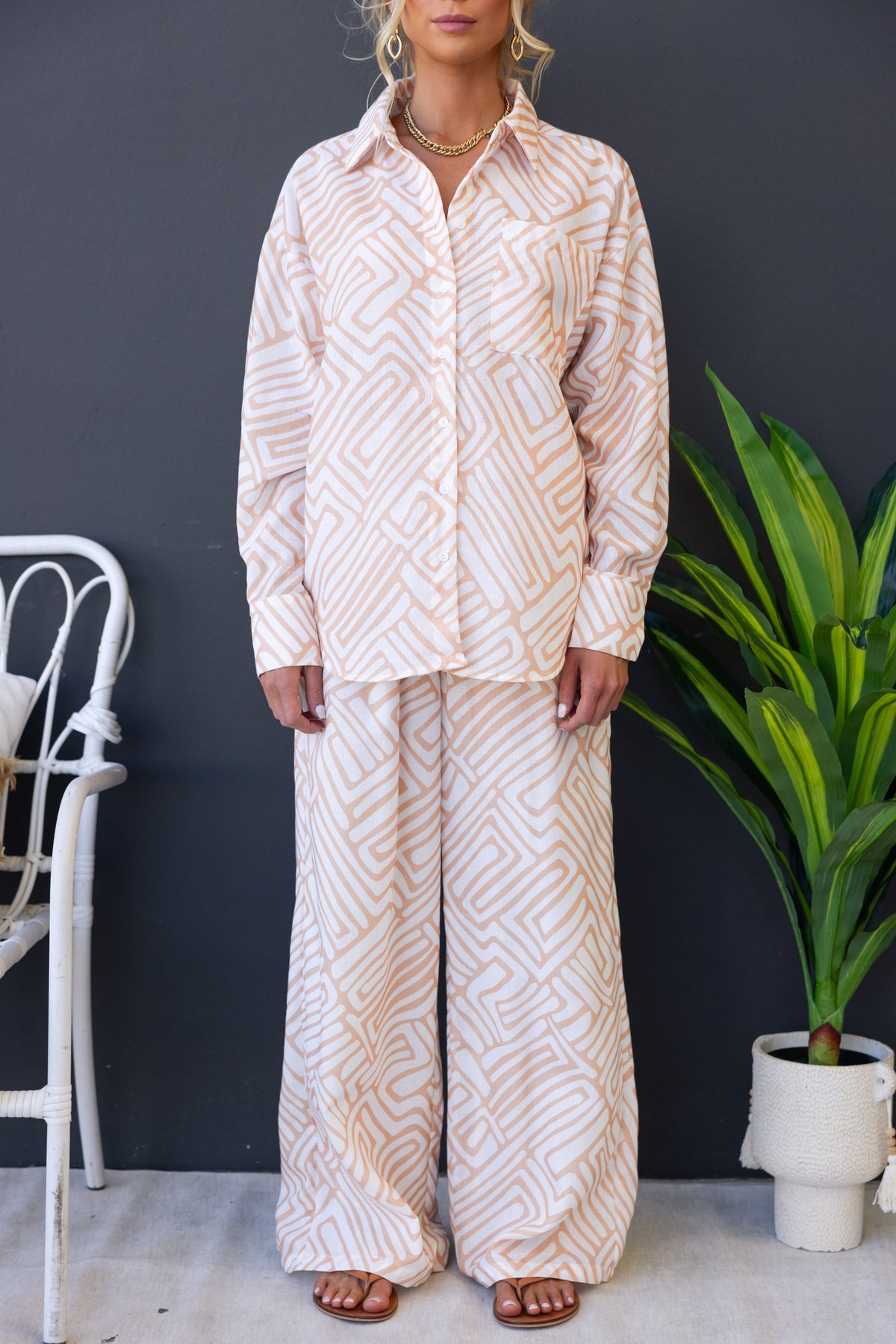 Model wearing Tari Shirt, a stylish button-up shirt with geometric patterns, paired with matching wide-leg pants.