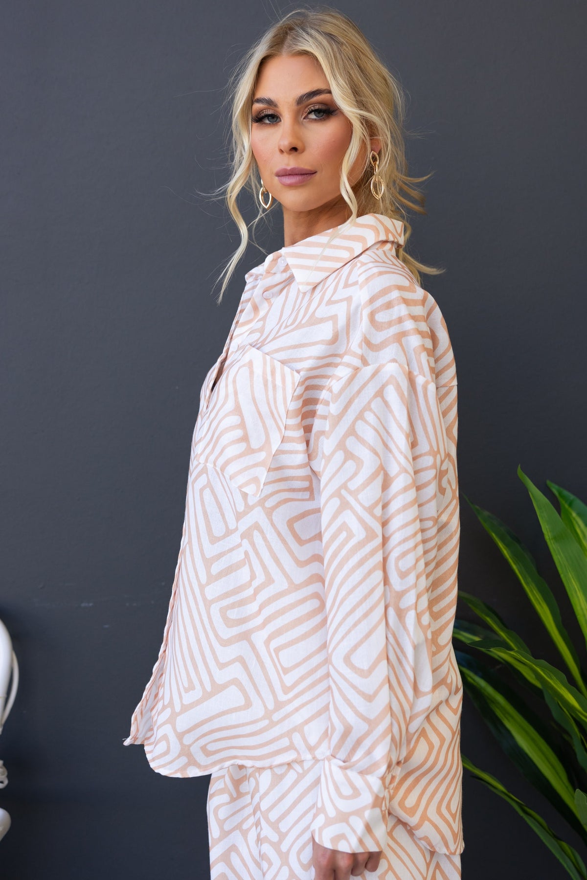 Tari Shirt in pink and white geometric pattern, featuring a button-up front and relaxed fit, styled by model.