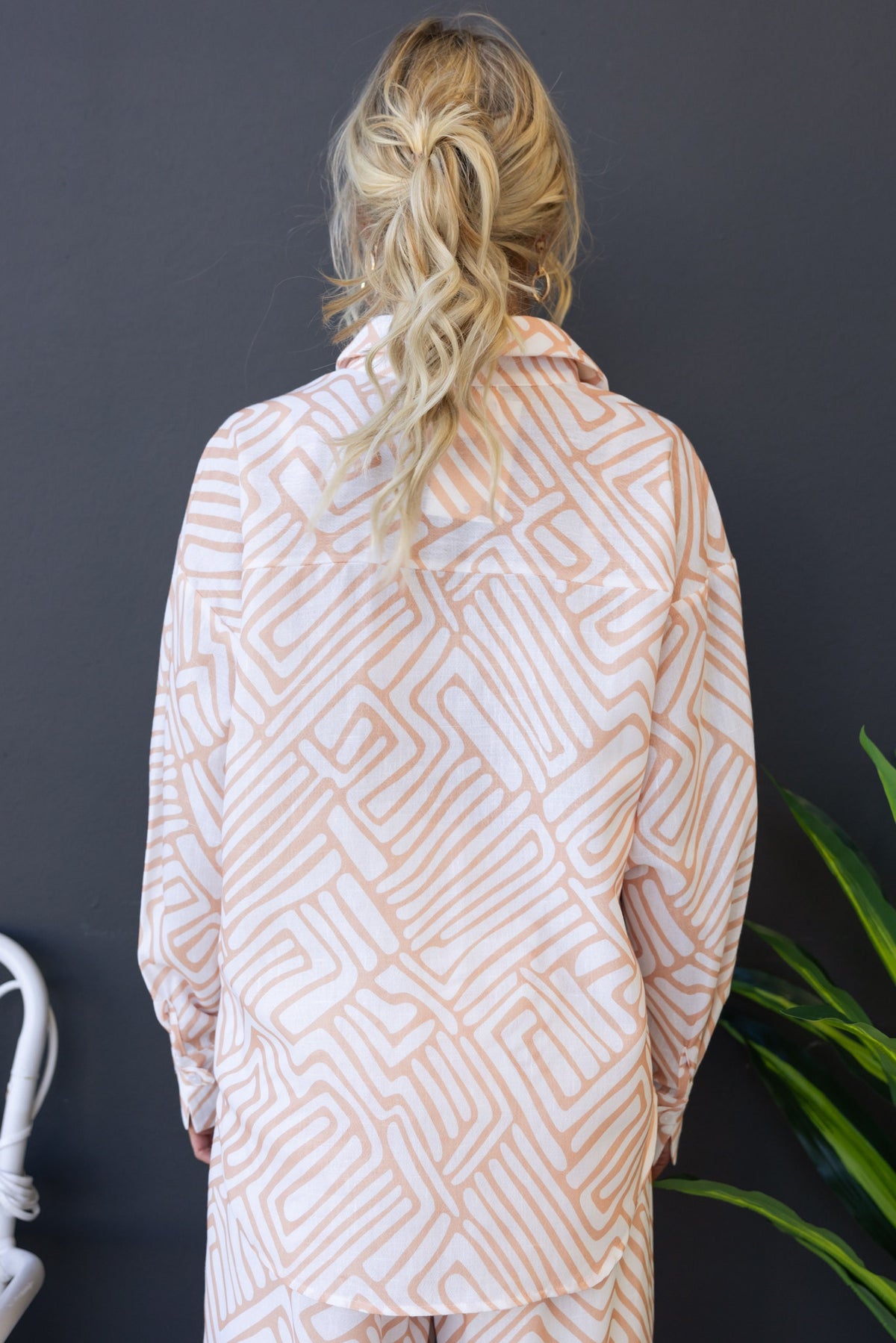 Back view of a woman wearing the Tari Shirt, featuring a modern geometric pattern on a relaxed-fit design.
