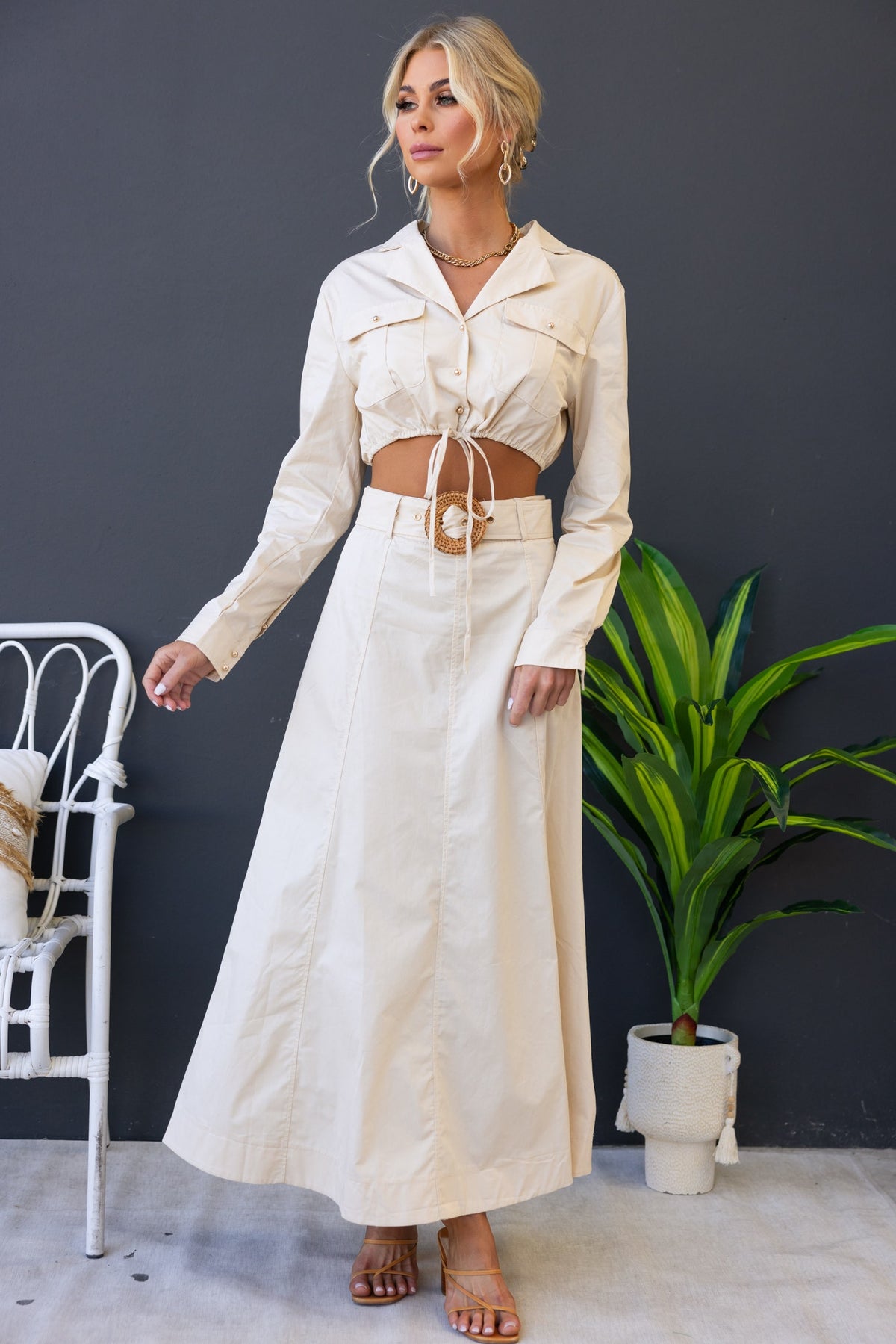 Model wearing the Crave Set: a crop top with drawstring and a maxi skirt with a removable belt in a chic setting.