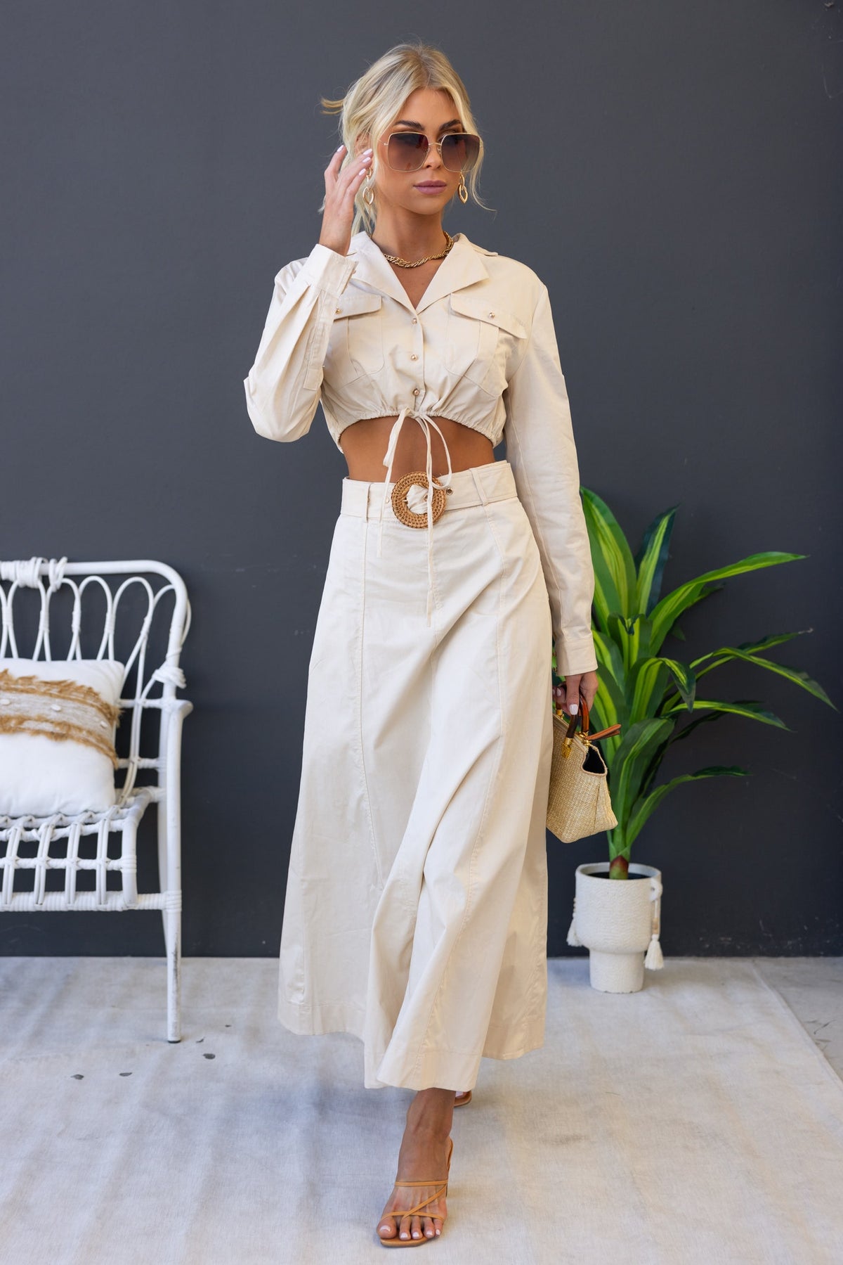 Model wearing Crave Set with crop top and maxi skirt, featuring a drawstring hem and removable belt in a light beige color.