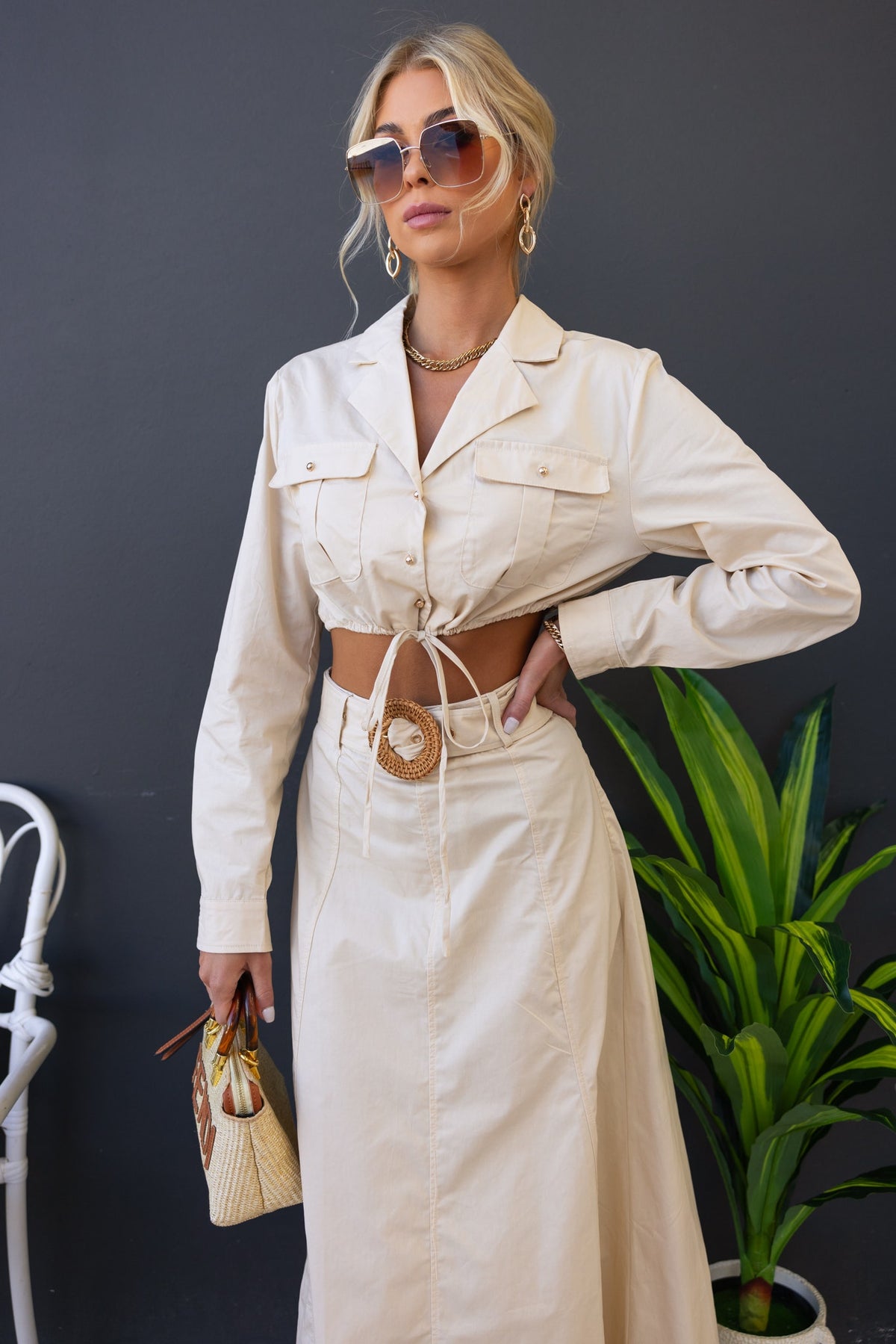 Chic model wearing Crave Set with button-up top and maxi skirt, showcasing a stylish cropped fit and removable belt.