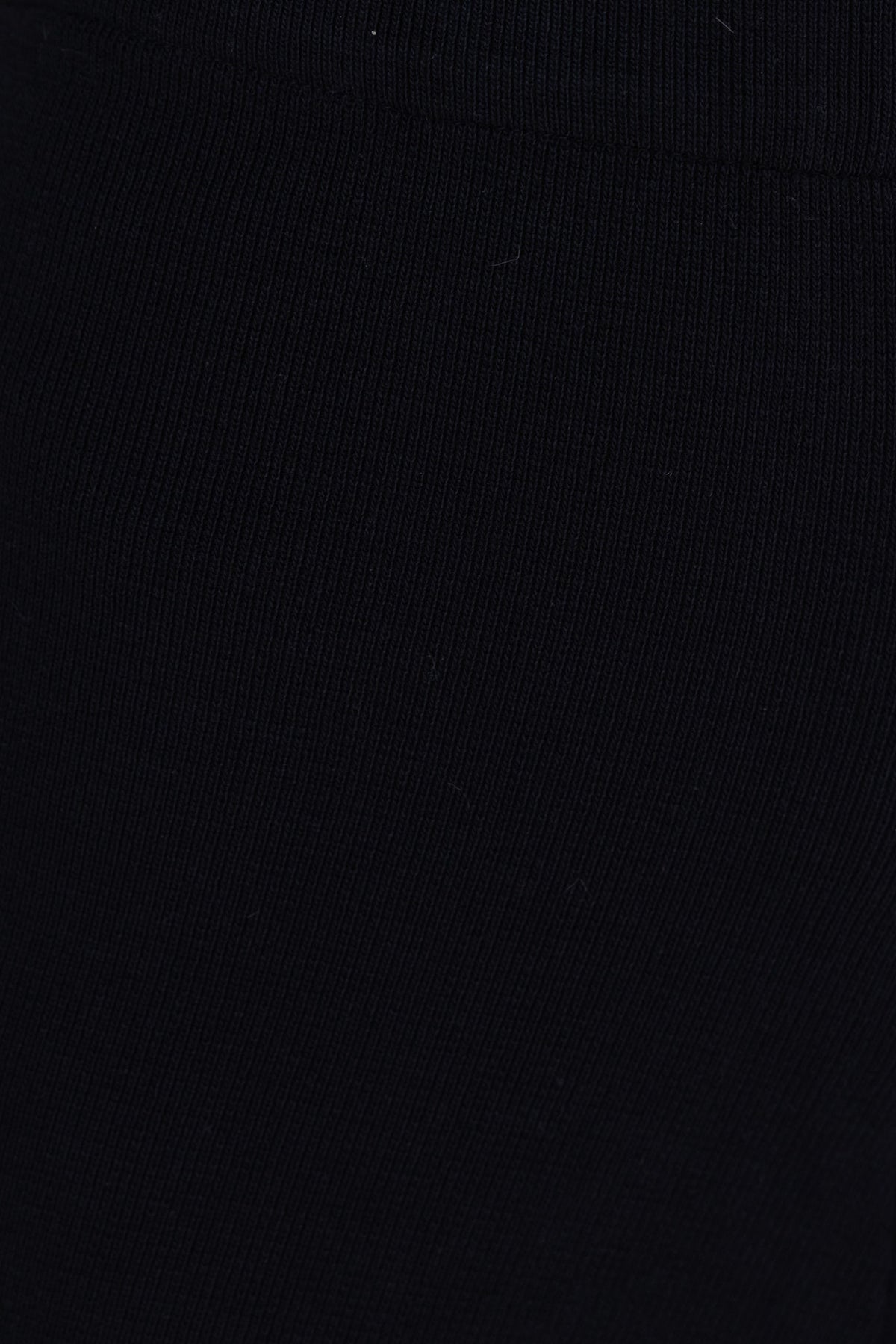 Close-up of a black ribbed knit fabric showcasing its soft texture and stretch, ideal for versatile styling.
