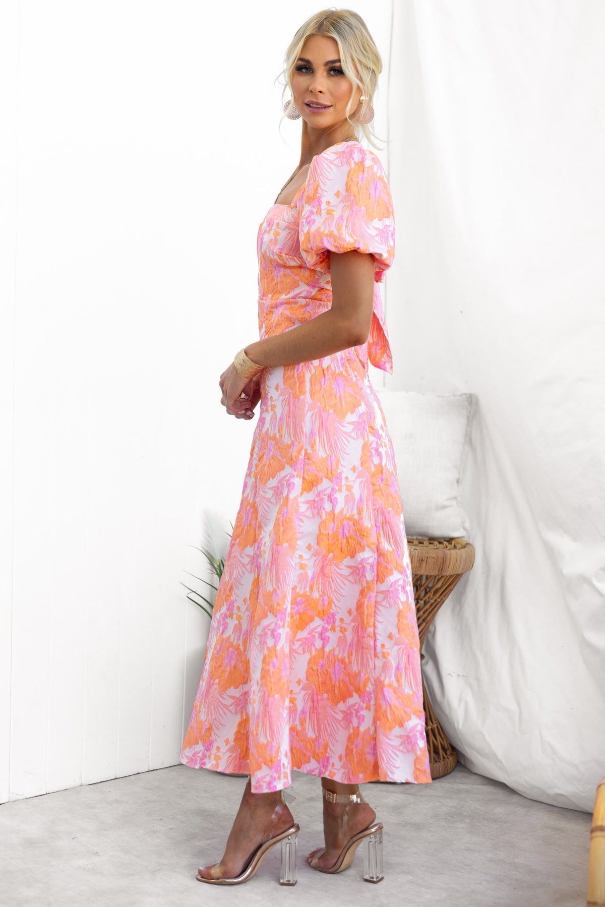 Model wearing the Sachin Maxi Dress featuring a square neckline and floral print in pink and orange tones.