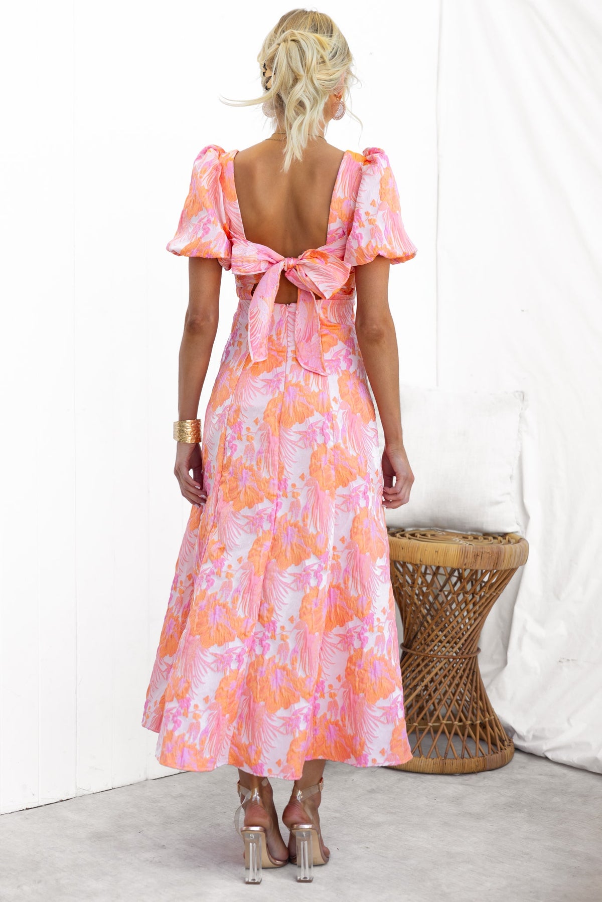 Back view of Sachin Maxi Dress featuring a square neckline, puff sleeves, and a tie-back design in vibrant pink floral pattern.