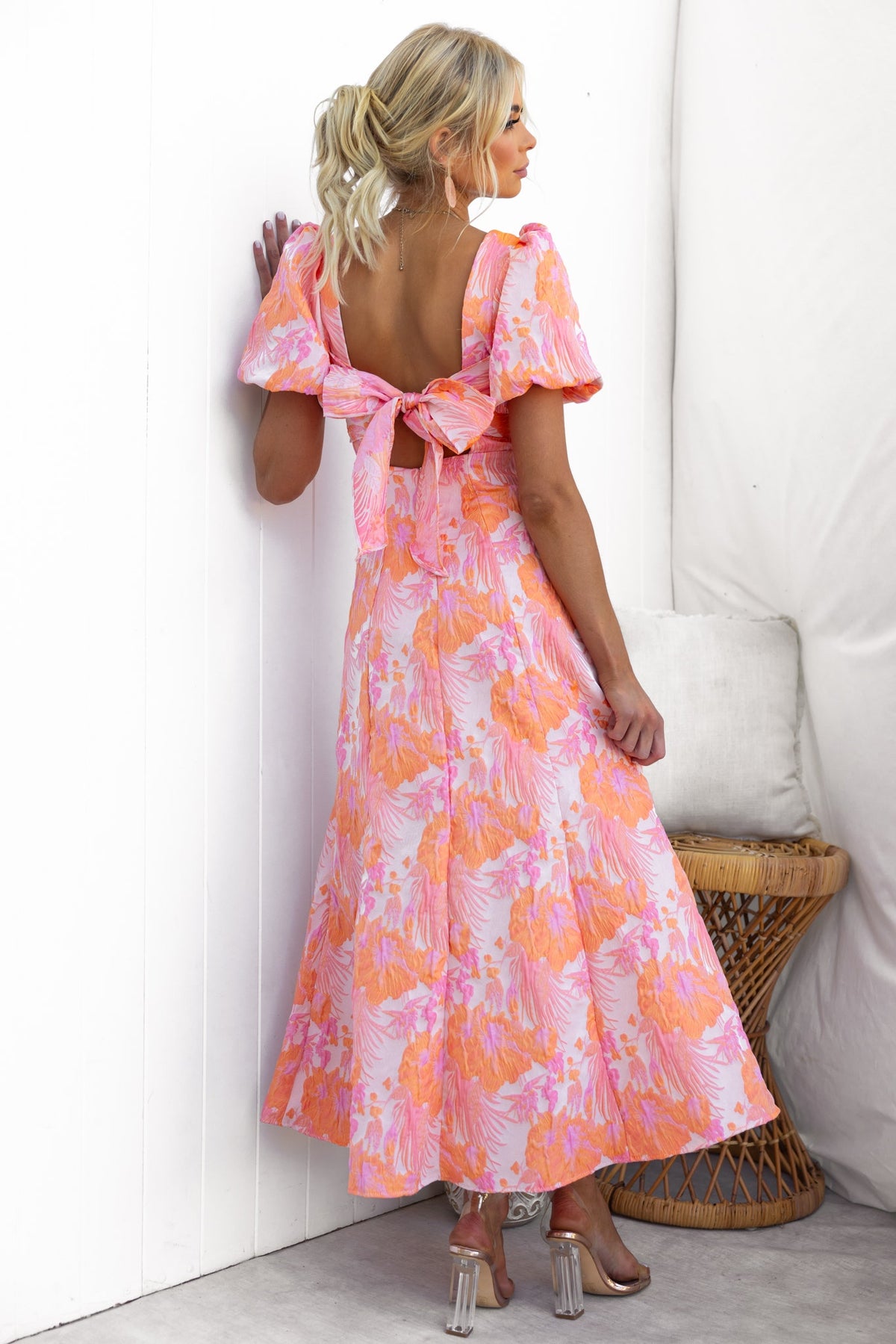 Back view of Sachin Maxi Dress featuring a square neckline, elastic sleeves, and a tie at the back, with a vibrant pink floral pattern.