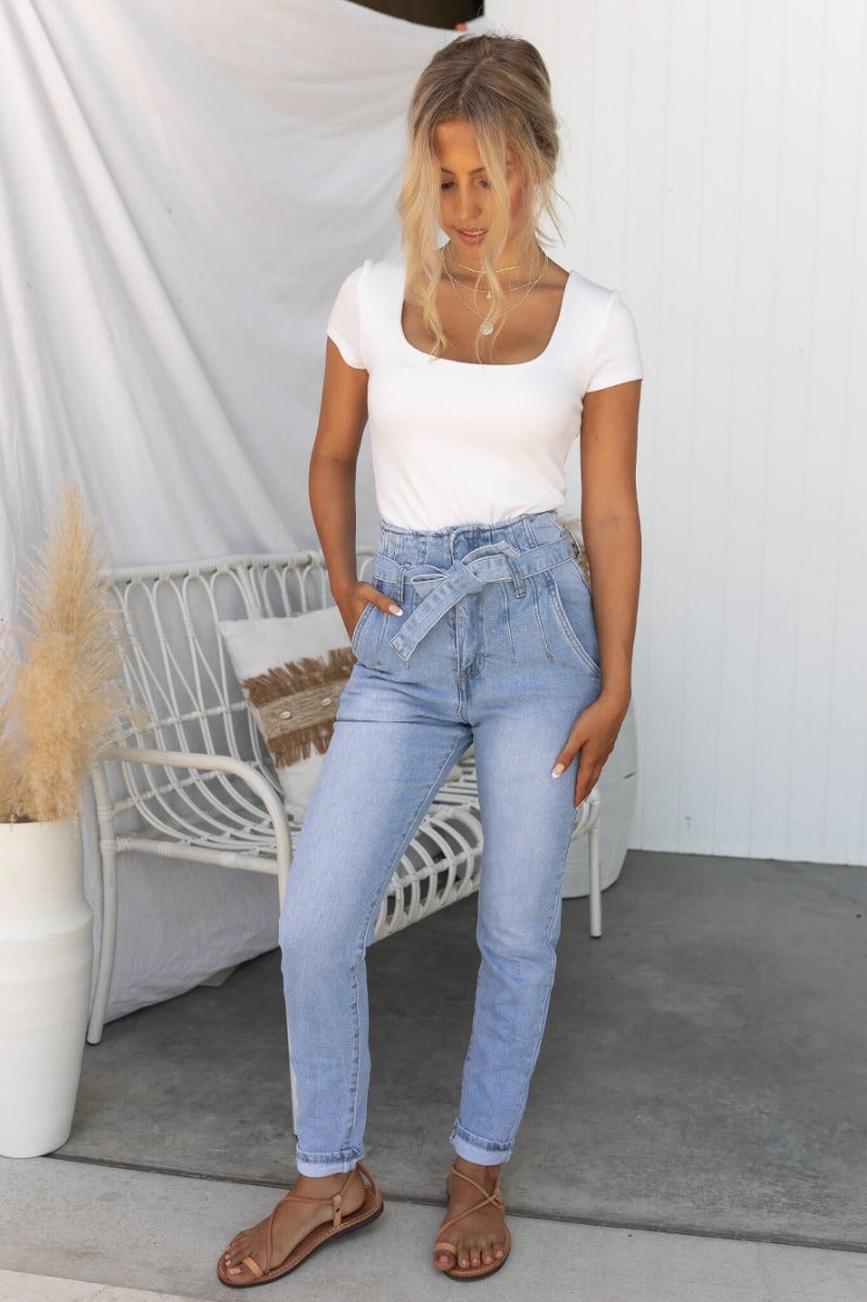 Model wearing New Hope Paper Bag Jeans with high waist and removable belt, styled with a white top.