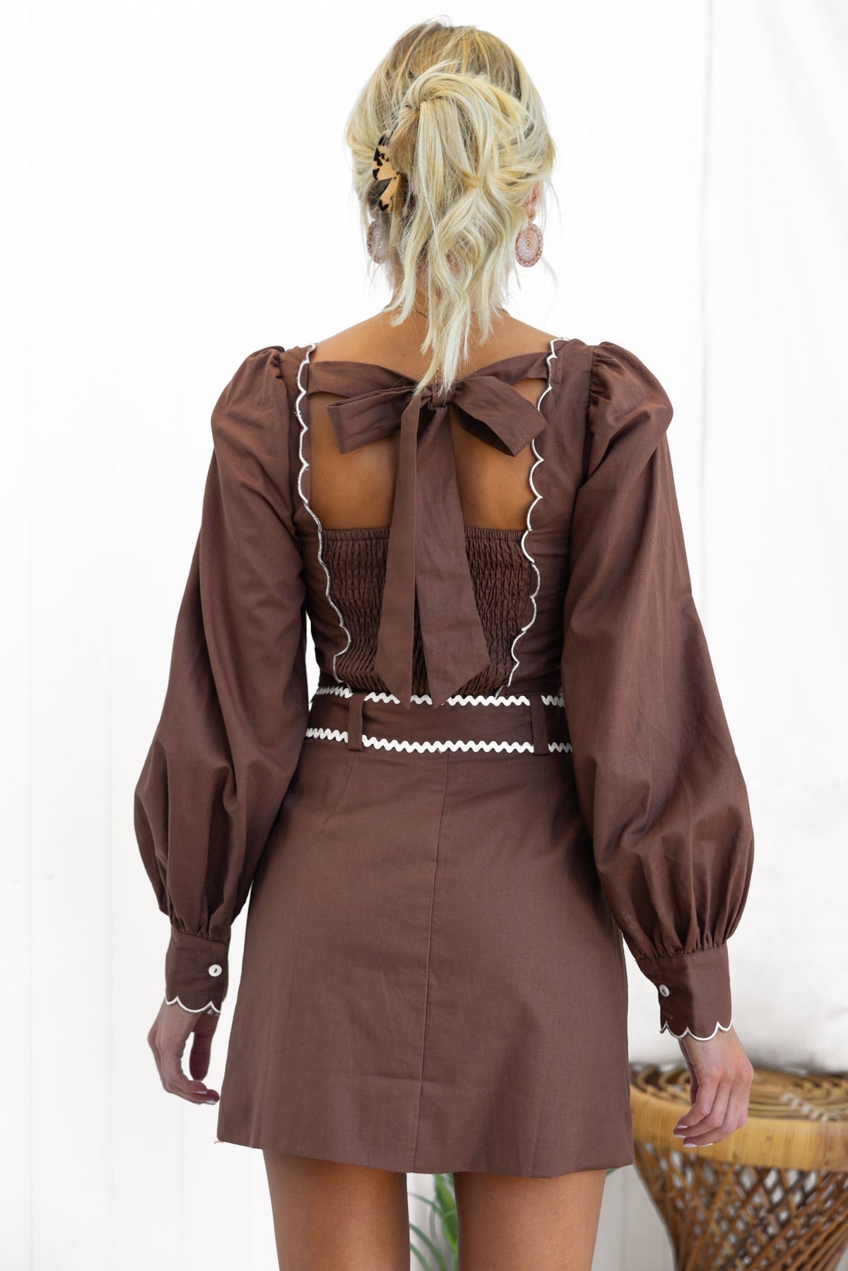 Back view of the Floreto Set featuring a square neckline, tie detail, and elasticized back in a stylish brown design.