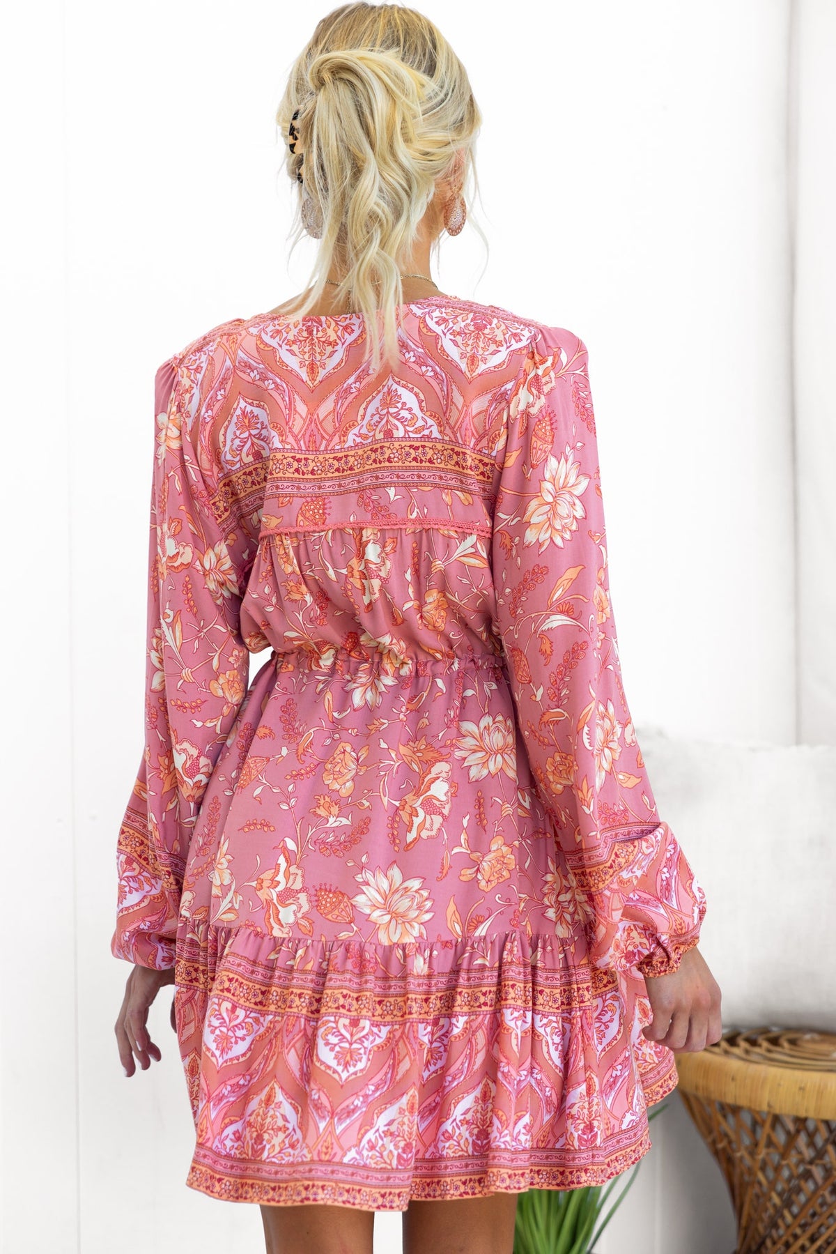 Back view of Eliana Dress, featuring a floral pattern, elastic sleeves, and adjustable waist drawstring.