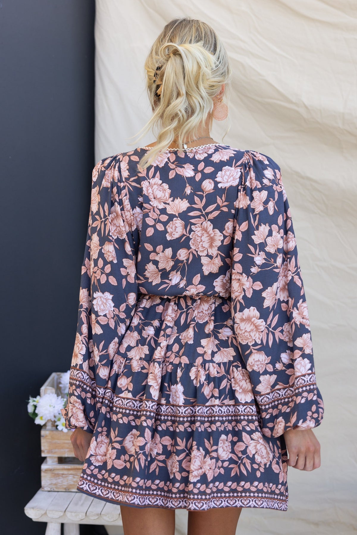 Back view of the Caputo Dress, featuring floral print, puffed sleeves, and a tiered hemline.