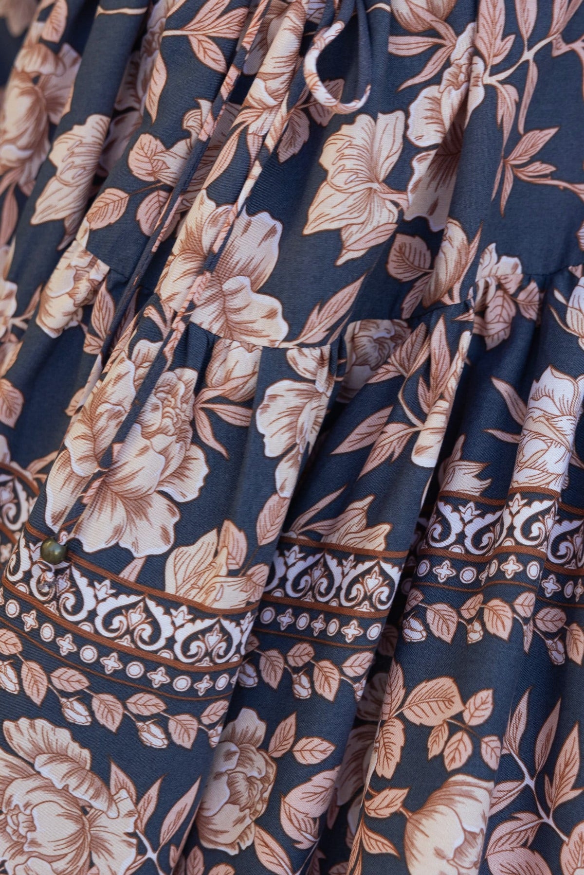 Navy floral patterned fabric of the Caputo Dress featuring elegant rose motifs and a decorative border.