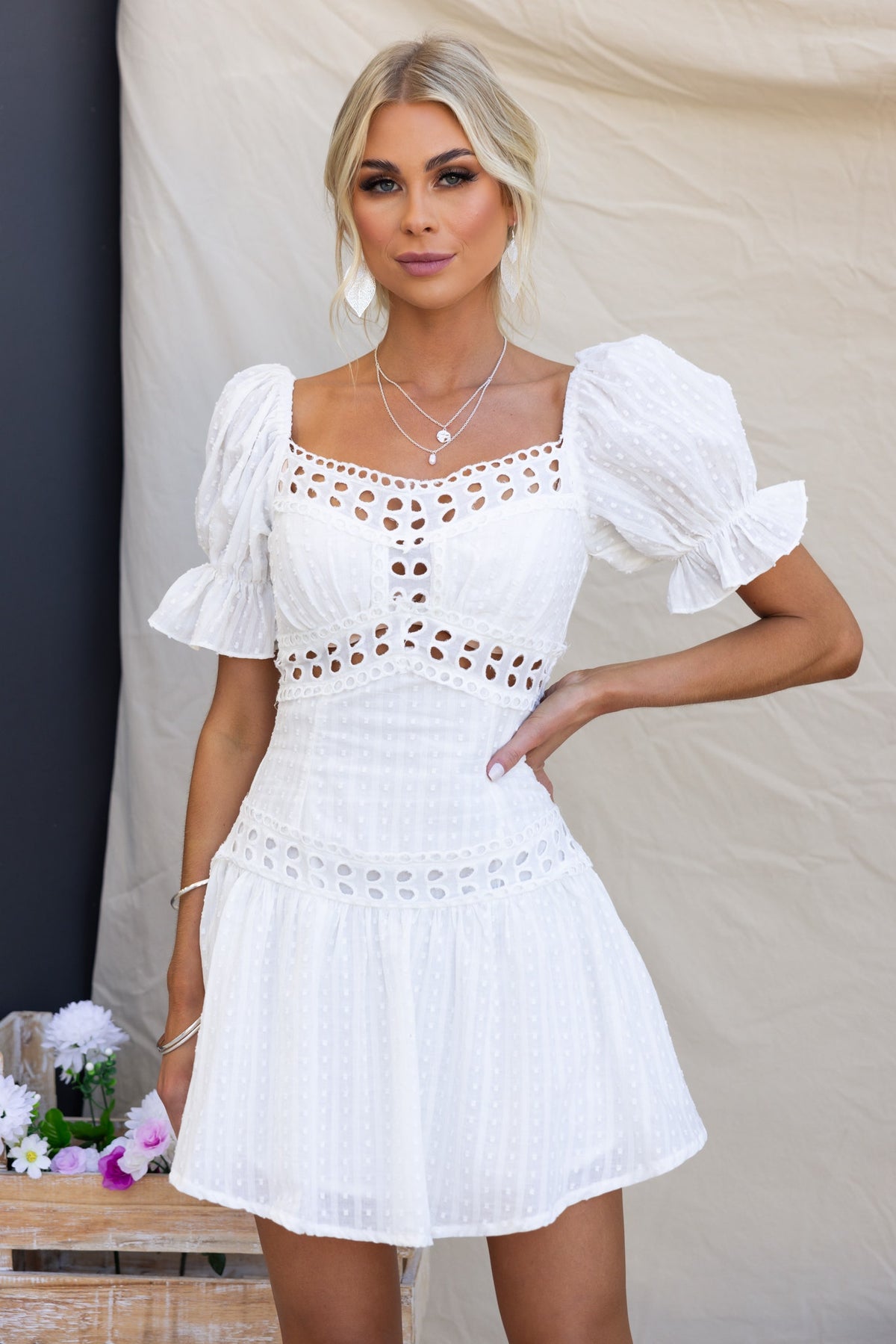 Model wearing a Ruby Love Dress, featuring textured fabric, elastic sleeves, and a fitted bodice with lace details.