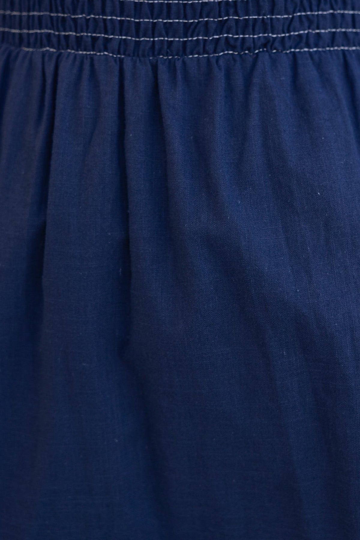 Close-up of navy cotton fabric with elastic waistband detail of the Kape Maxi Dress.