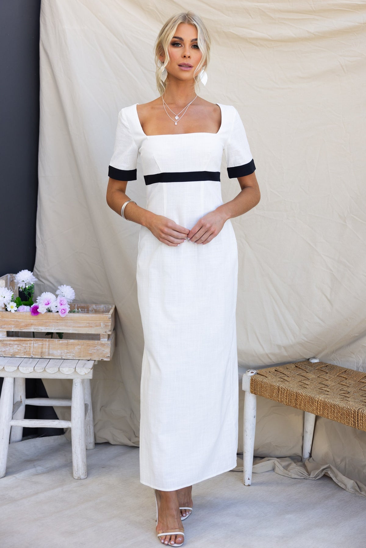 Soria Maxi Dress featuring a square neckline, back split, and black detailing, styled with minimal accessories.