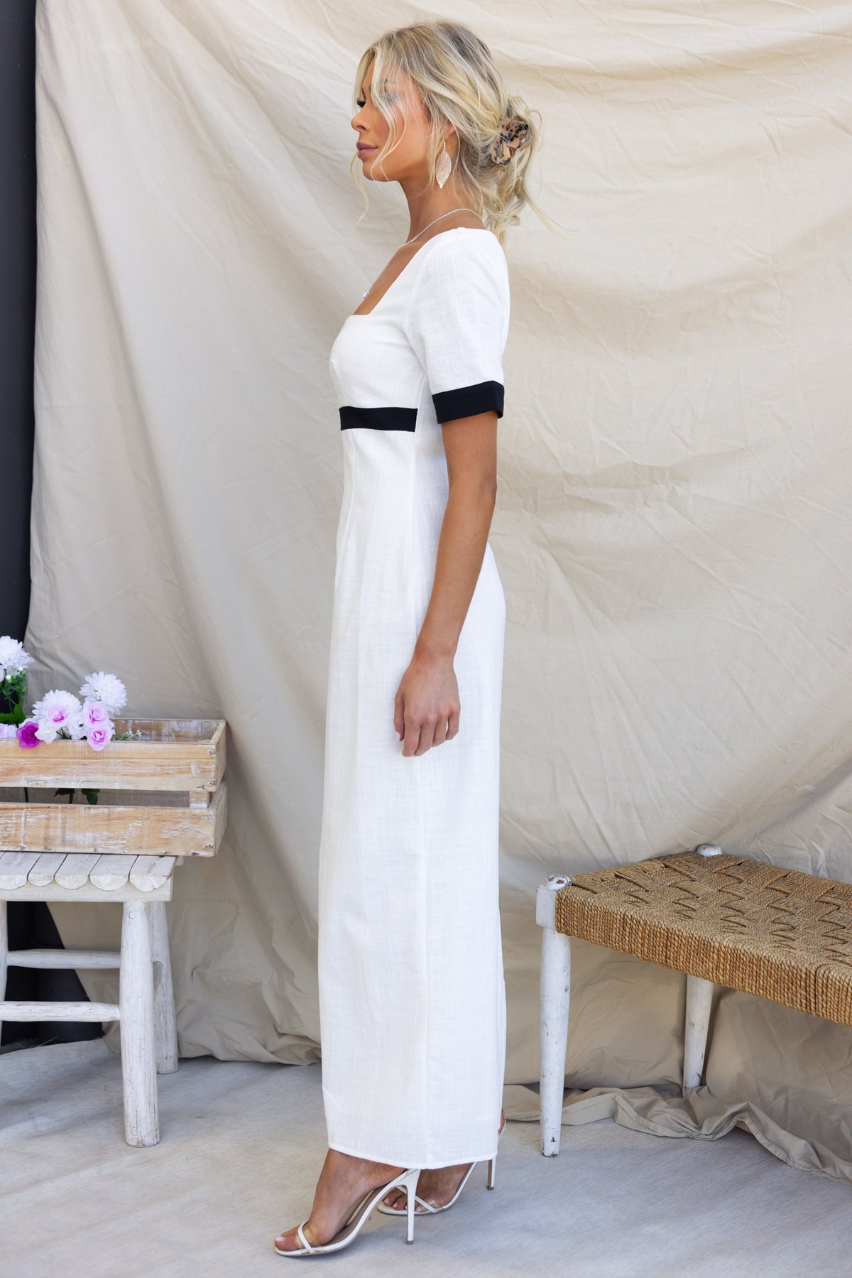 Side view of Soria Maxi Dress featuring square neckline, black accents, and back split detail.