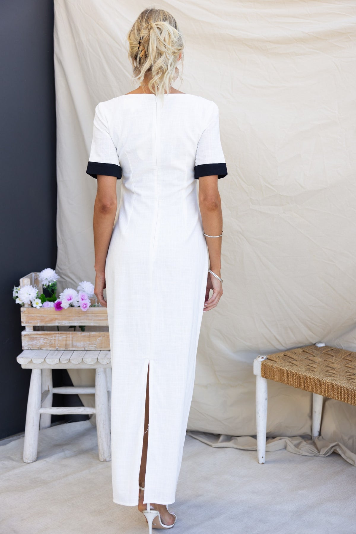 Back view of Soria Maxi Dress featuring a split, square neckline, and short sleeves with a stylish design.