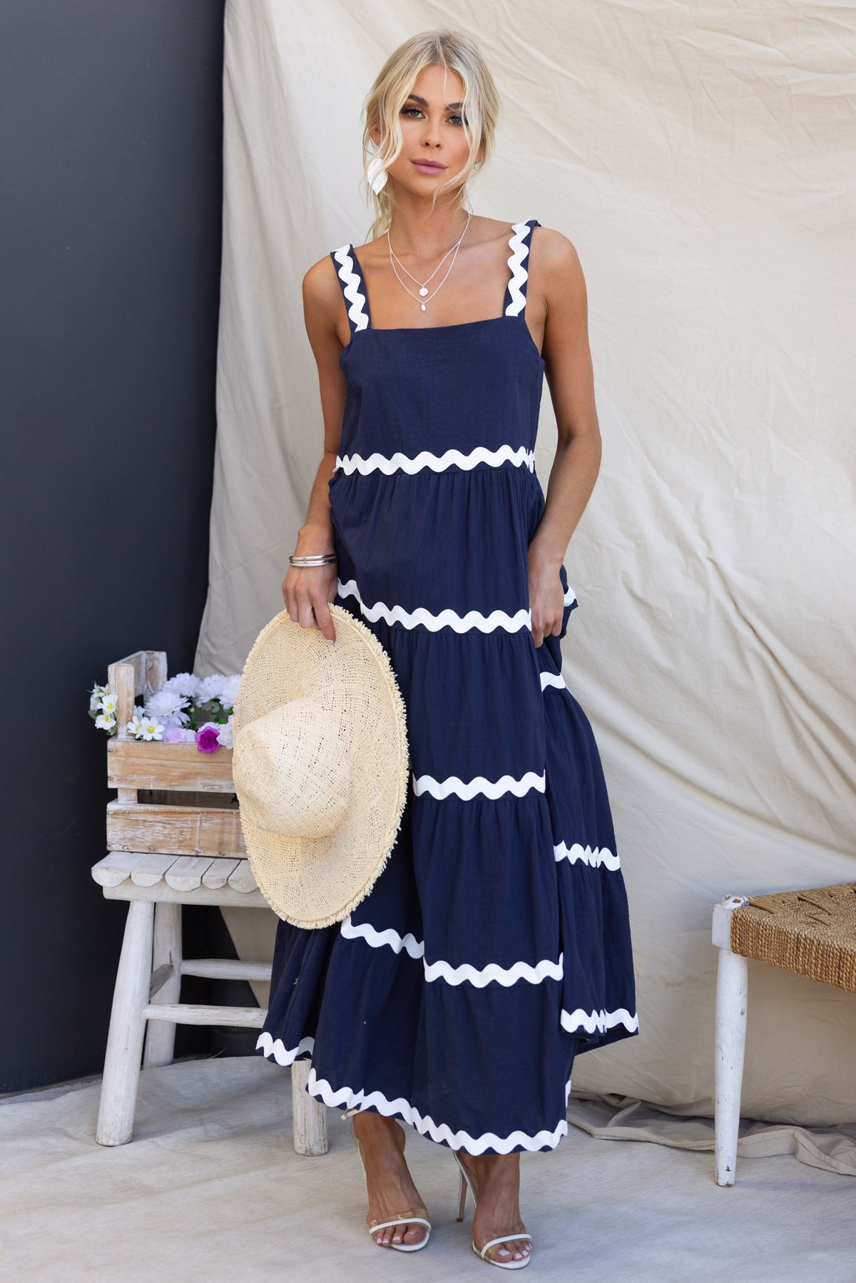 Navy Nori Maxi Dress with white trim, featuring square neckline, pockets, and relaxed fit, styled with a straw hat.