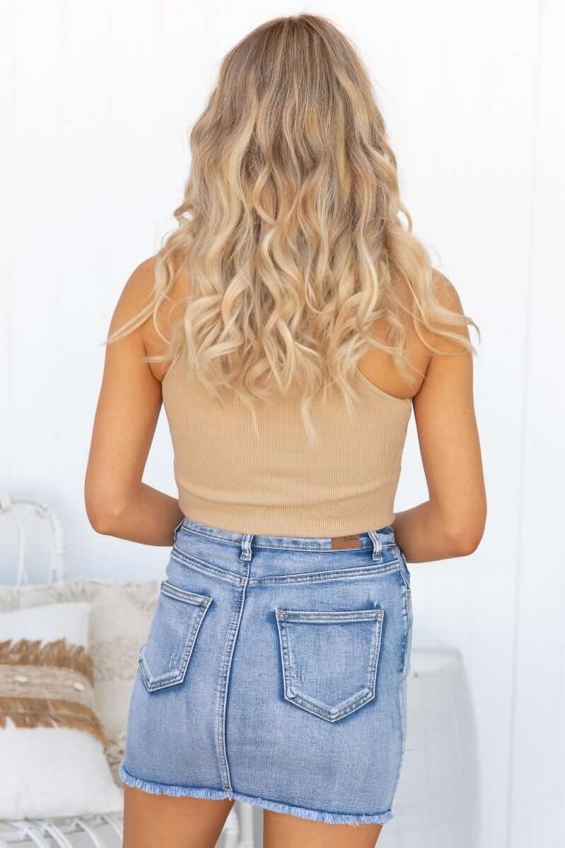 Back view of a woman wearing the Nice For What Skirt with pockets and distressed details, paired with a beige top.