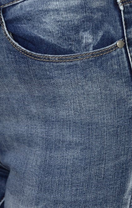 Close-up of Juicebox Jeans showcasing distressed denim texture and raw hem details.