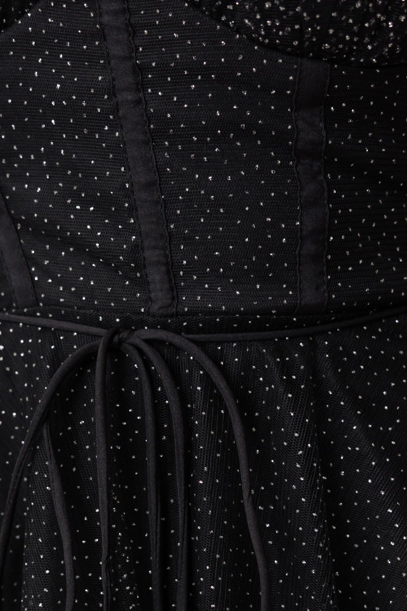 Close-up of Florence Midi Dress detailing, showcasing black tulle fabric with glitter and adjustable cross-over straps.