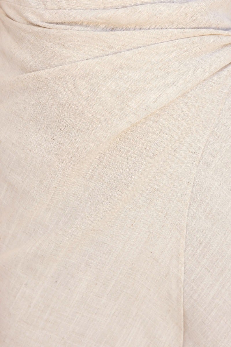 Close-up of the creamy linen blend fabric of a strapless Gala Midi Dress showcasing the wrap skirt detail.