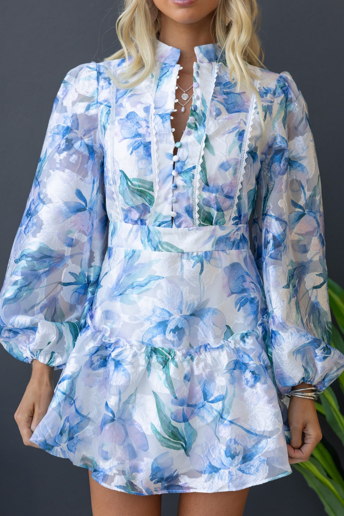 Wisteria Dress featuring a high neckline, button-up bust, and floral chiffon design with elastic cuffs.