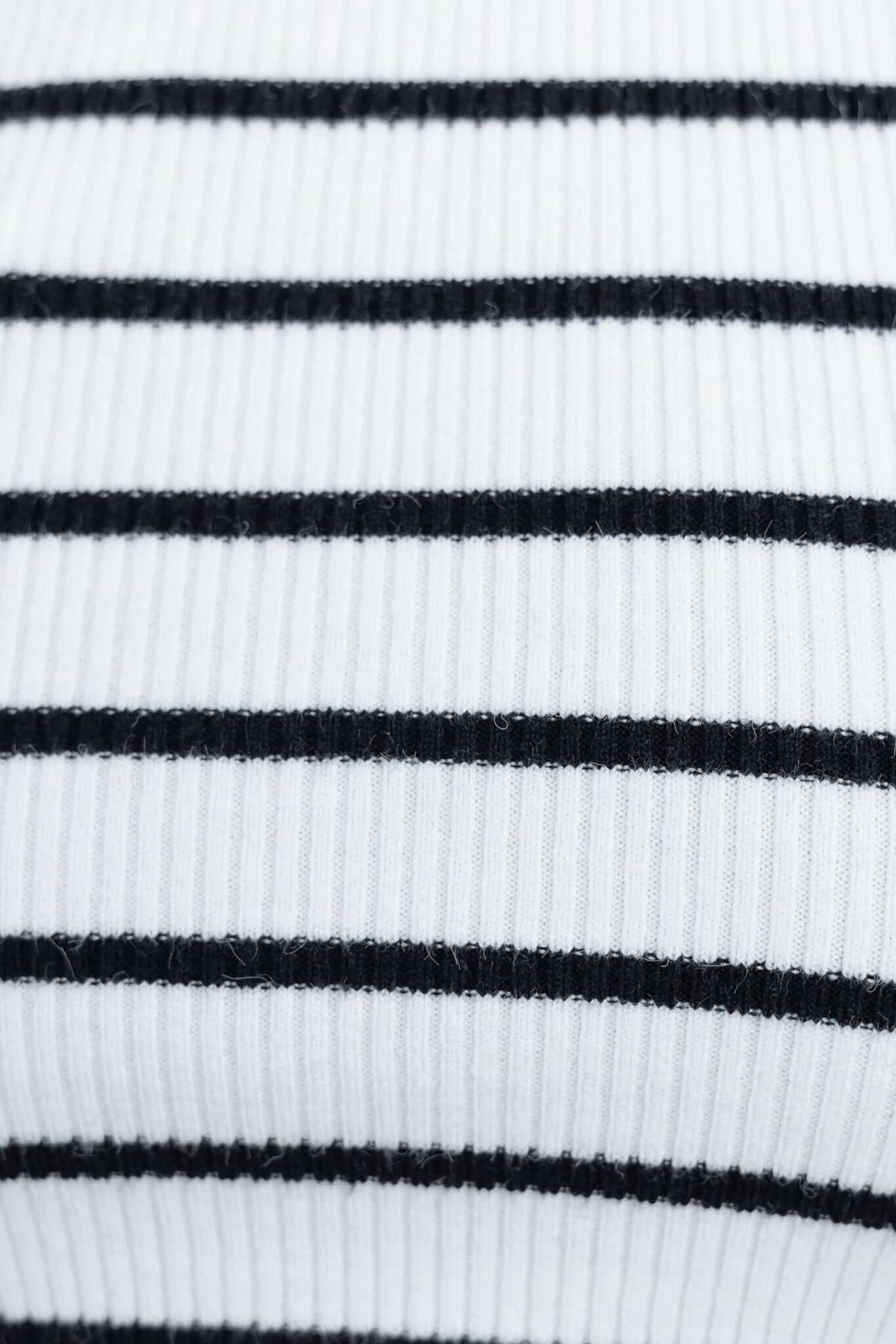 Close-up of ribbed knit fabric in white and black stripes, showcasing the texture and pattern used in Nowlan Pants.