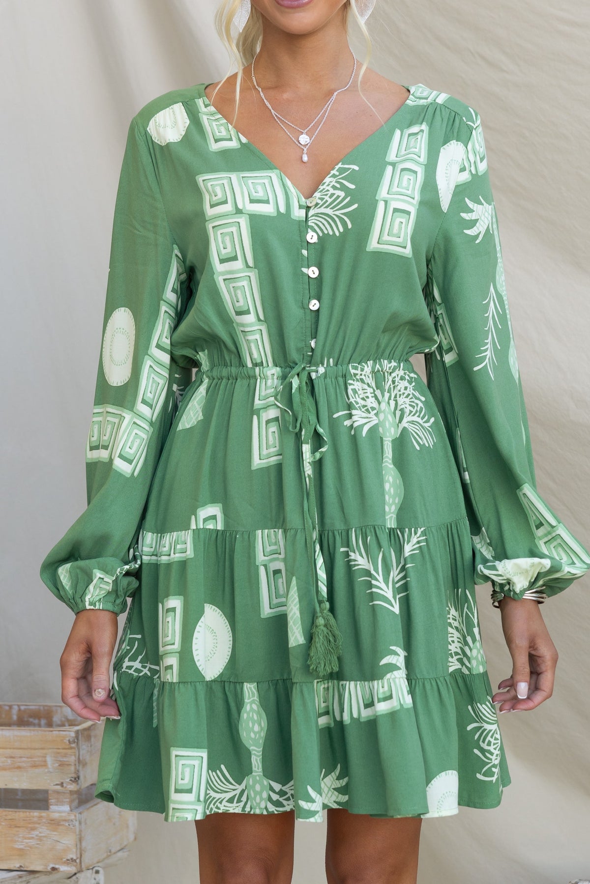 Gratias Dress in green with V-neckline, button-up front, elastic waistband and cuffs, featuring a stylish tropical print.