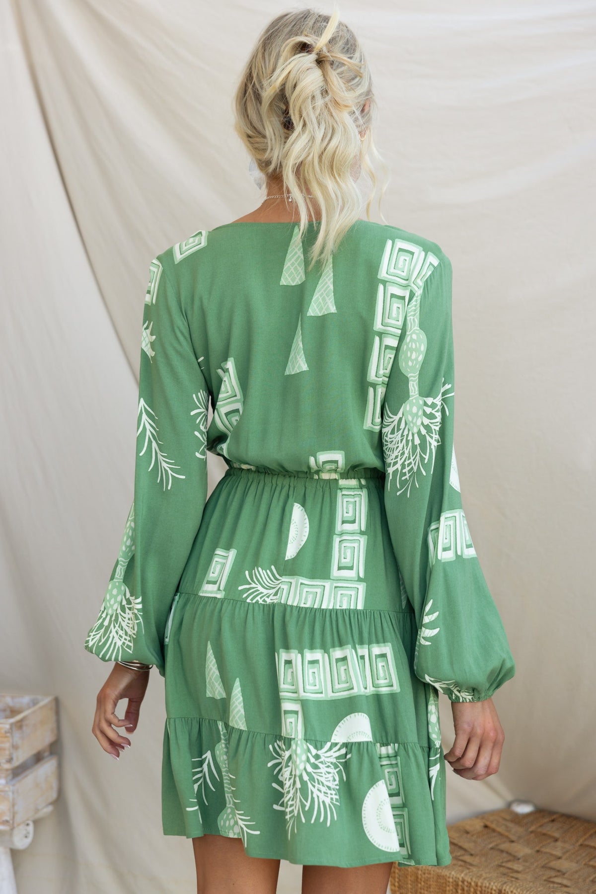 Back view of the Gratias Dress with a green geometric pattern and elastic waistband, perfect for a stylish casual look.