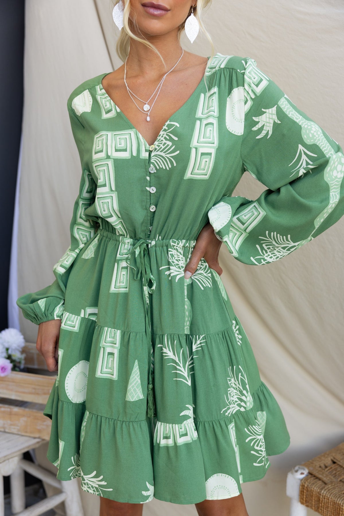 Gratias Dress in green with V-neckline, button-up front, elastic waistband, and tiered skirt design.
