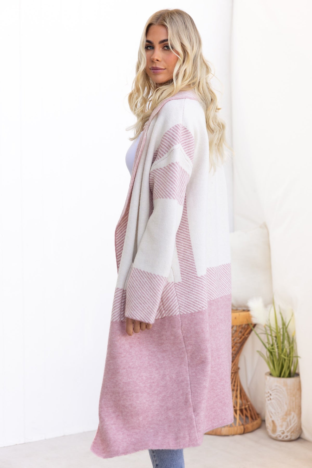 Kellan Cardigan in pink and white, longline fit with collar, featuring pockets, modeled by a woman with long wavy hair.