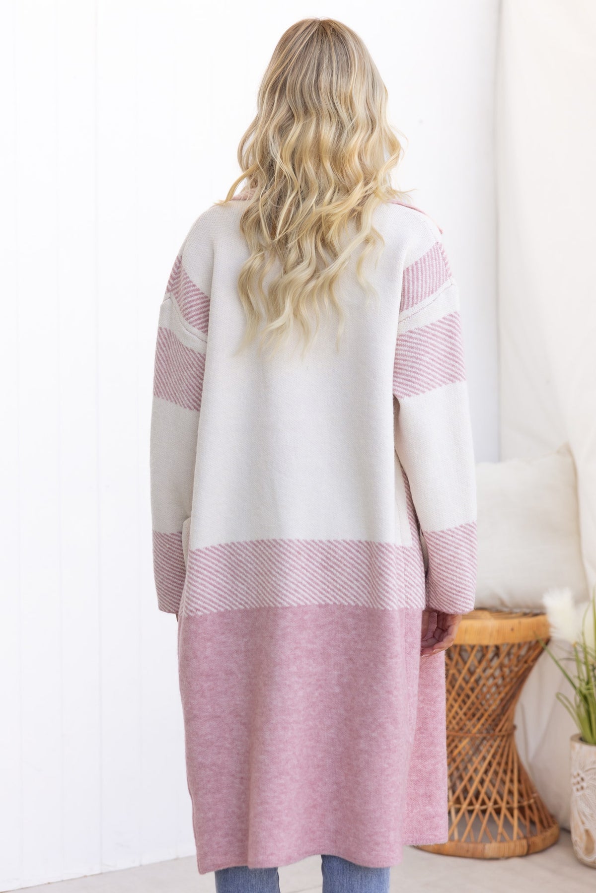 Back view of Kellan Cardigan in cream and pink, featuring longline fit, knit material, and stylish collar.